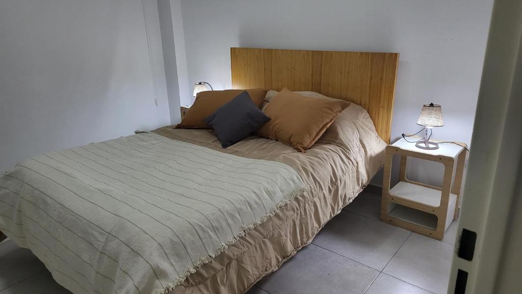 a bedroom with a bed with a wooden head board at Luminoso departamento en Morón in Morón
