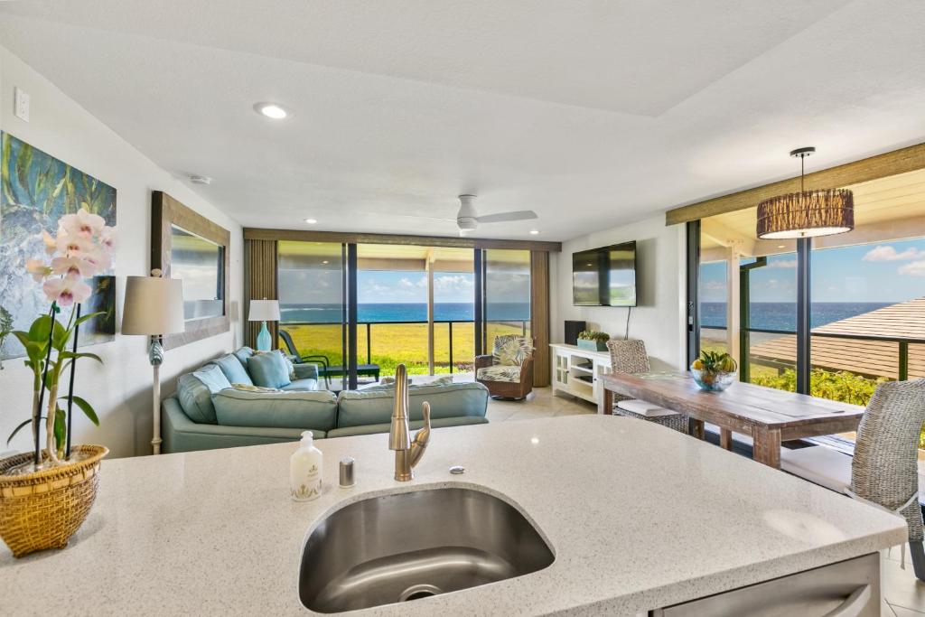 a kitchen and living room with a view of the ocean at Renovated 2br Condo with Ocean Views - Alekona Kauai in Koloa