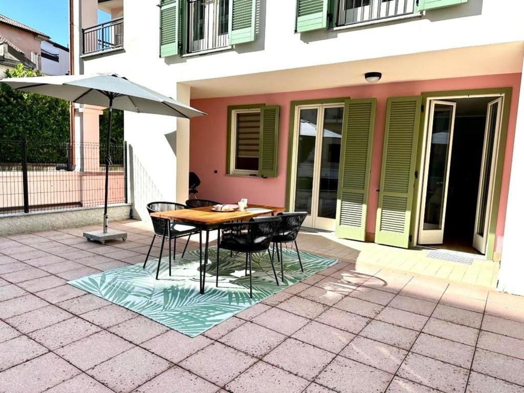 una mesa y sillas con una sombrilla en el patio en L'appartamento di Alessandra, en Verbania