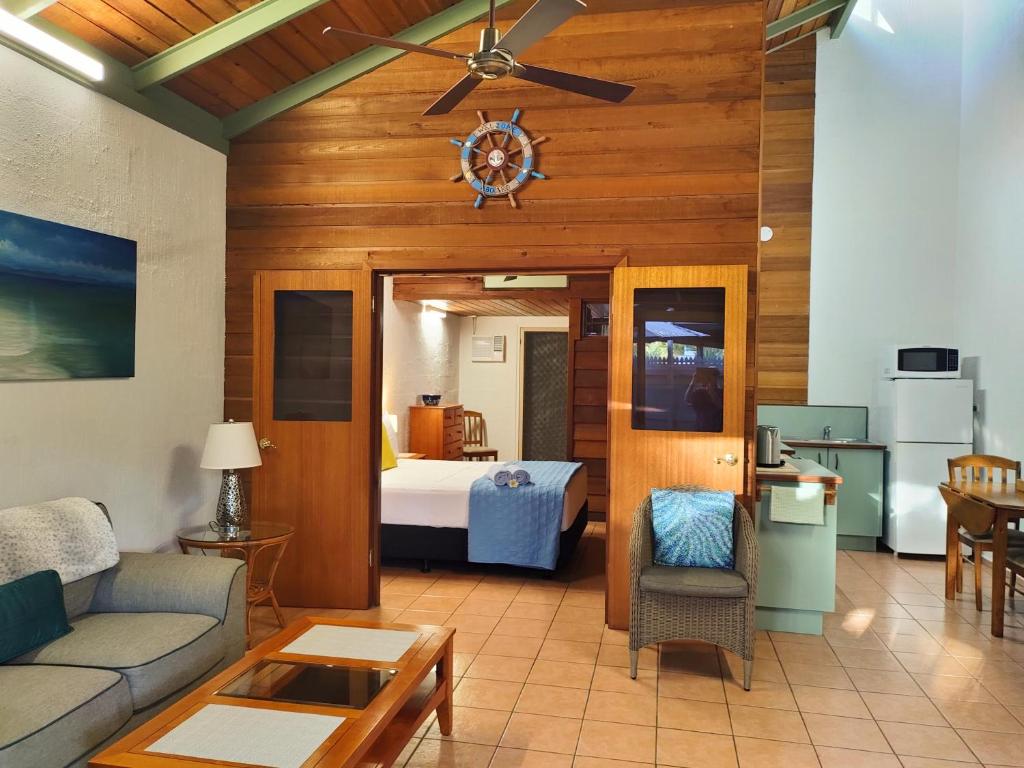 ein Wohnzimmer mit Sofa und ein Schlafzimmer in der Unterkunft Beachside Cottage - A Private Peaceful Hidden Gem 50m to Beach in Nelly Bay