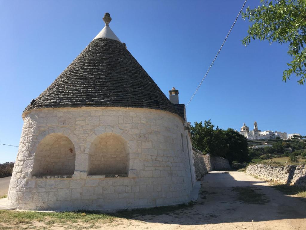 an old building with a cross on top of it at TRULLI LE 2 NICCHIE in Locorotondo
