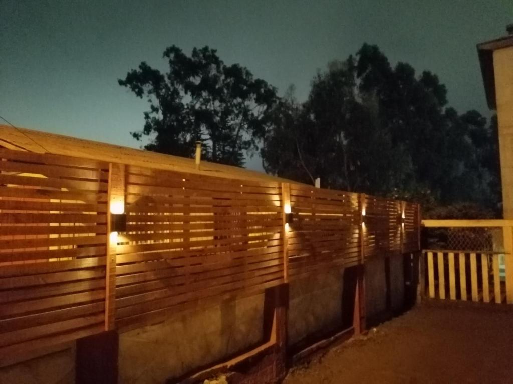 ein Holzzaun mit Licht in der Nacht in der Unterkunft La estancia en la Isla in Isla Negra