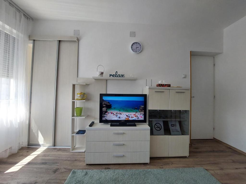 a living room with a flat screen tv on a cabinet at Apartman Kokin Grad in Prijedor