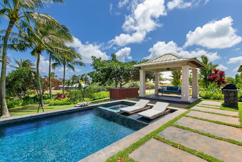 een zwembad met een prieel en 2 ligstoelen bij Luxury 5 Bed Home with Pool and Spa- Alekona Kauai in Koloa