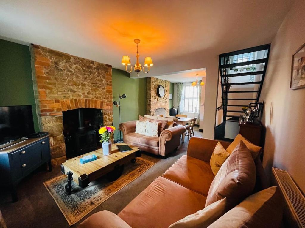 a living room with a couch and a fireplace at Bluebell Cottage Heritage Town nr Brecon Beacons with hot tub in Blaenavon