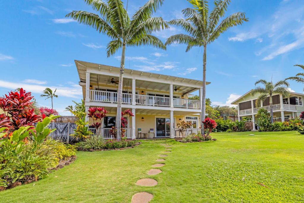- une vue sur l'extérieur d'une maison avec des palmiers dans l'établissement Cute 4br home steps to the Ocean - Alekona Kauai, à Koloa