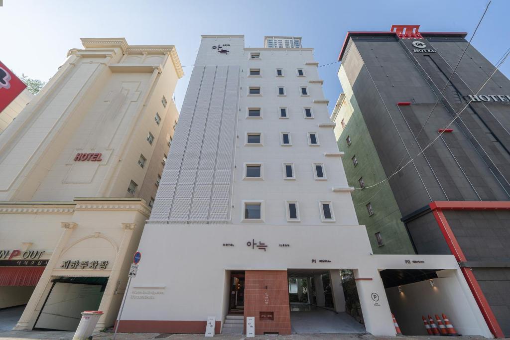 two tall buildings next to each other on a street at The Hyoosik Aank Hotel Ilsan Tanhyeon in Goyang