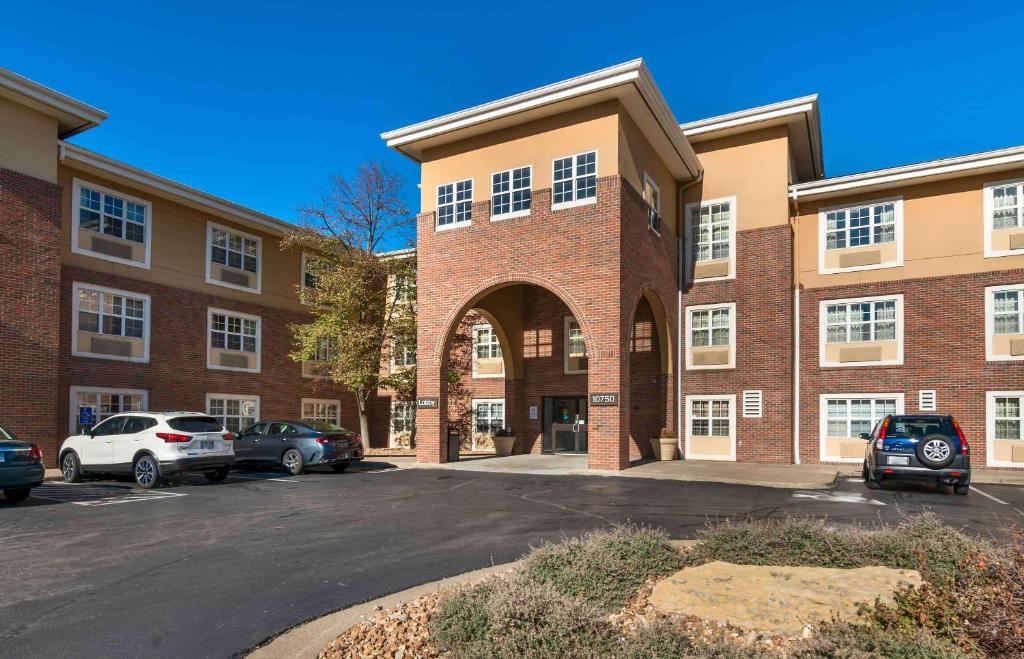 a brick building with cars parked in a parking lot at Extended Stay America Suites - Kansas City - Overland Park - Quivira Rd in Lenexa