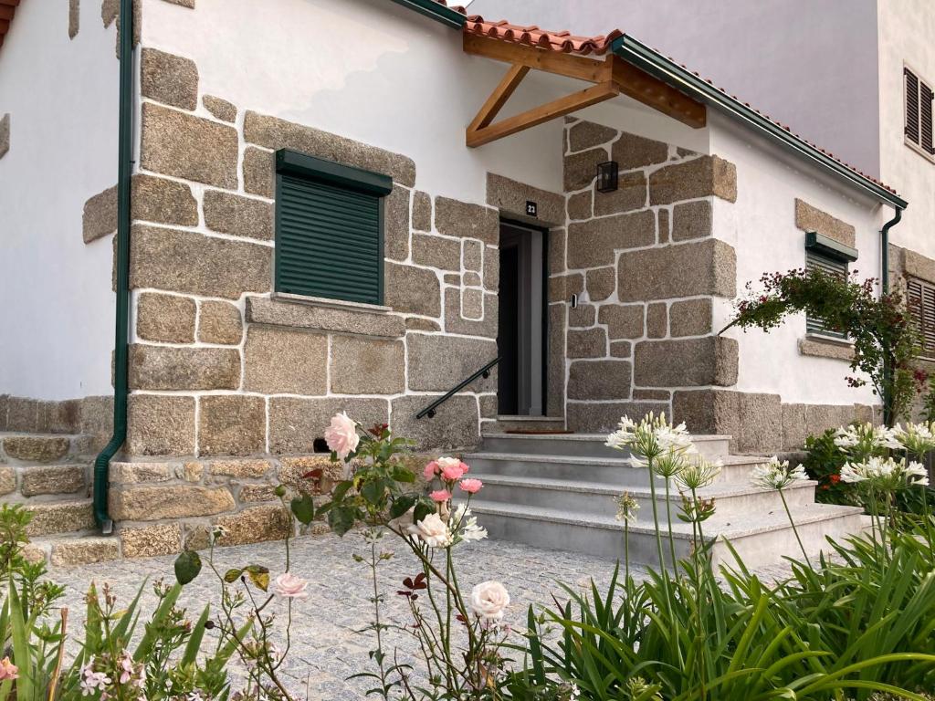 una casa in pietra con scale che conducono a una porta di Casa do Bairro a Seia