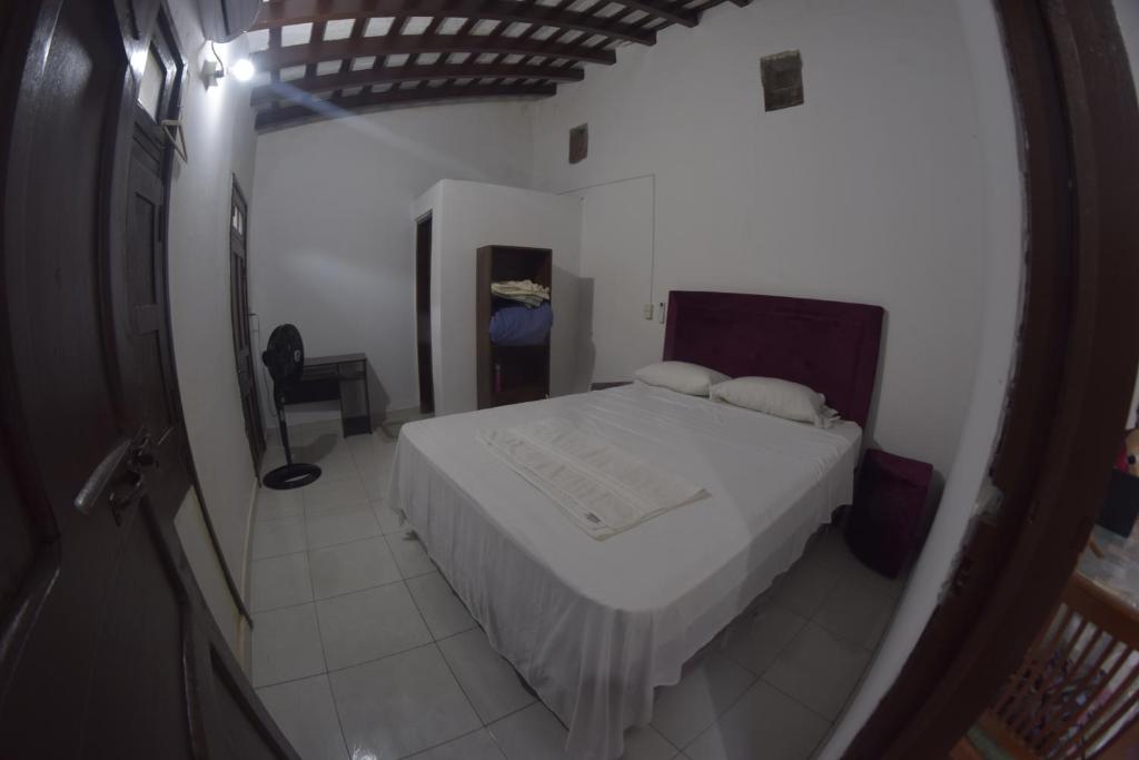 Schlafzimmer mit einem weißen Bett und einem Spiegel in der Unterkunft Hotel La Mansión in Villarrica