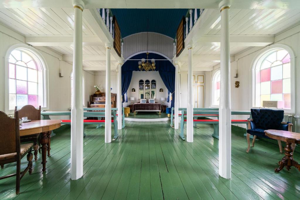 Cette grande chambre est dotée de colonnes blanches et d'un plafond bleu. dans l'établissement Hótel Blönduós, à Blönduós