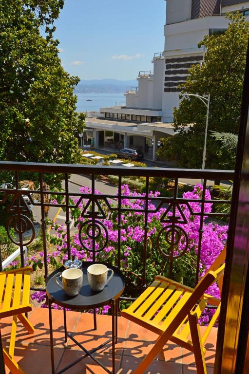 a table with two cups on a balcony with purple flowers at Romeo&amp;Juliet in Opatija