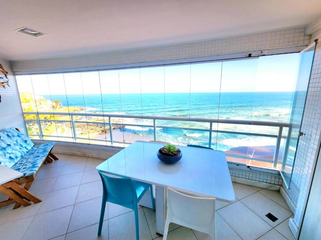 a dining room with a table and a view of the ocean at Vista Top em Ondina in Salvador