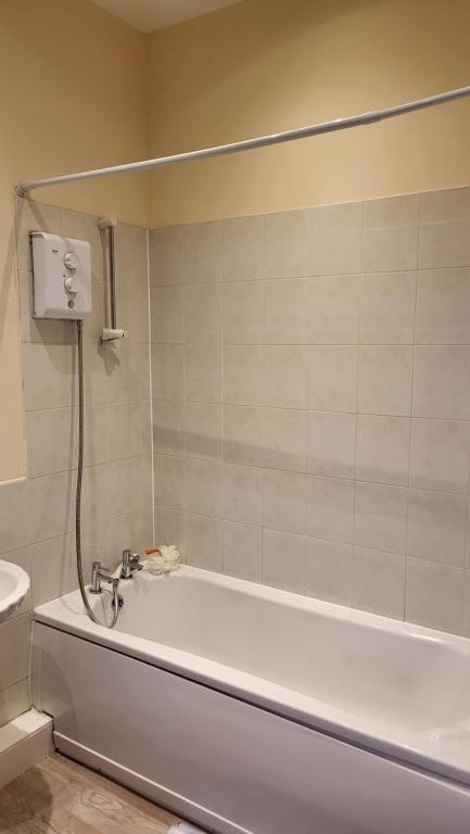 a white bath tub in a bathroom with a toilet at Memory Homes MM H2 in Dukinfield