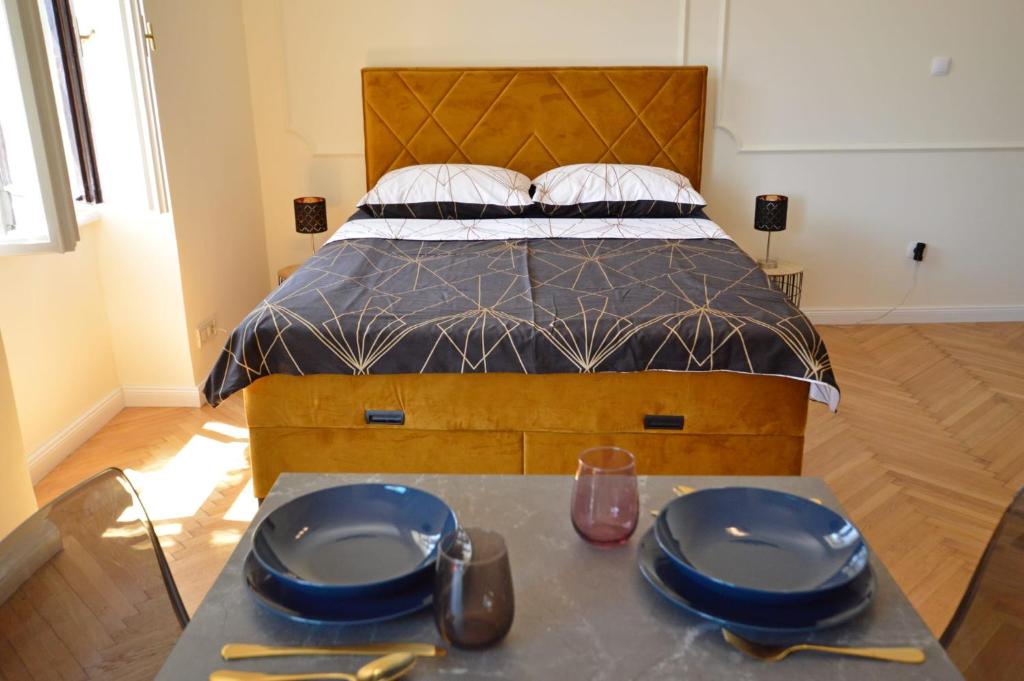 a bedroom with a bed with two blue plates on a table at Romeo&amp;Juliet in Opatija