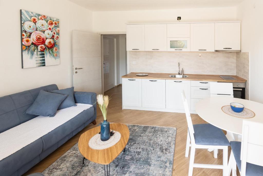 a living room with a blue couch and a table at White Apartment in Kumbor