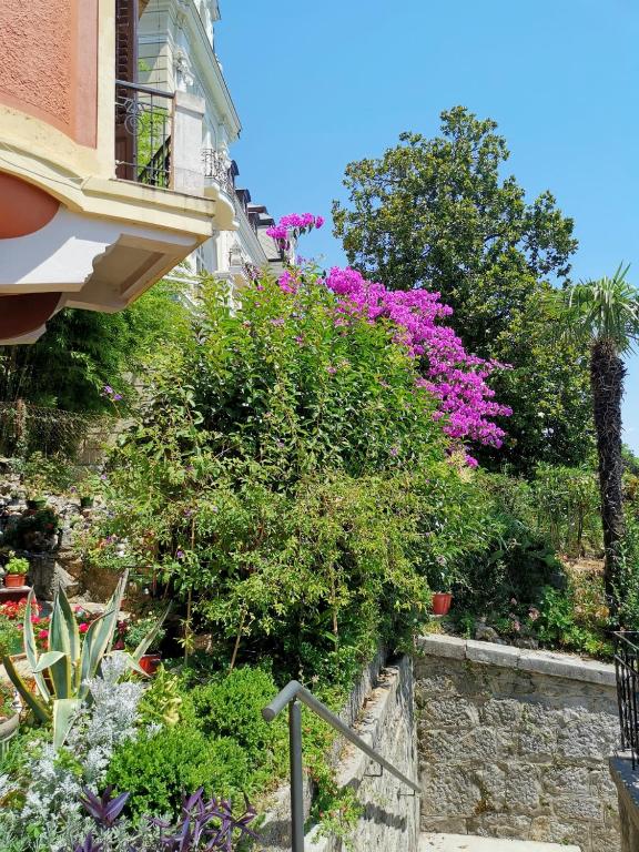 a garden with pink flowers next to a building at Romeo&amp;Juliet in Opatija