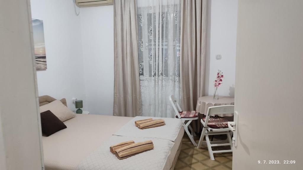 a small room with two beds and a table at Pejovic Guest House in Sutomore