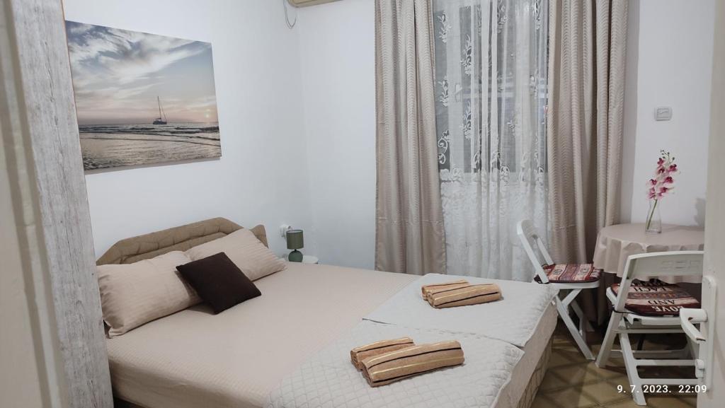 a small bedroom with a white bed and a table at Pejovic Guest House in Sutomore