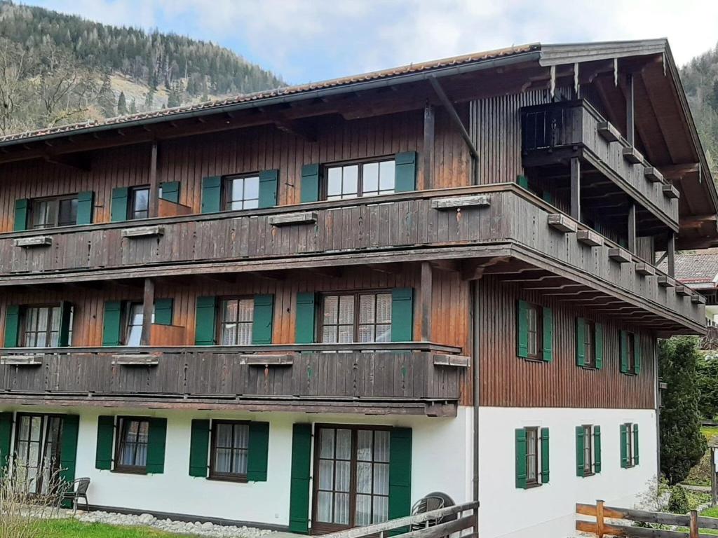 - un bâtiment en bois avec un balcon au-dessus dans l'établissement Magnificent Holiday Home in Bayrischzell with Infrared Sauna, à Bayrischzell