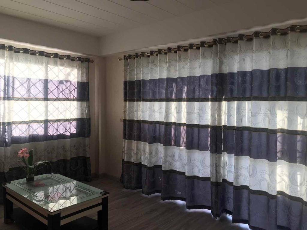 Habitación con cortinas, mesa y ventana en Nadi Town Newly Renovated 2nd Floor Suite with Large Terrace en Nadi