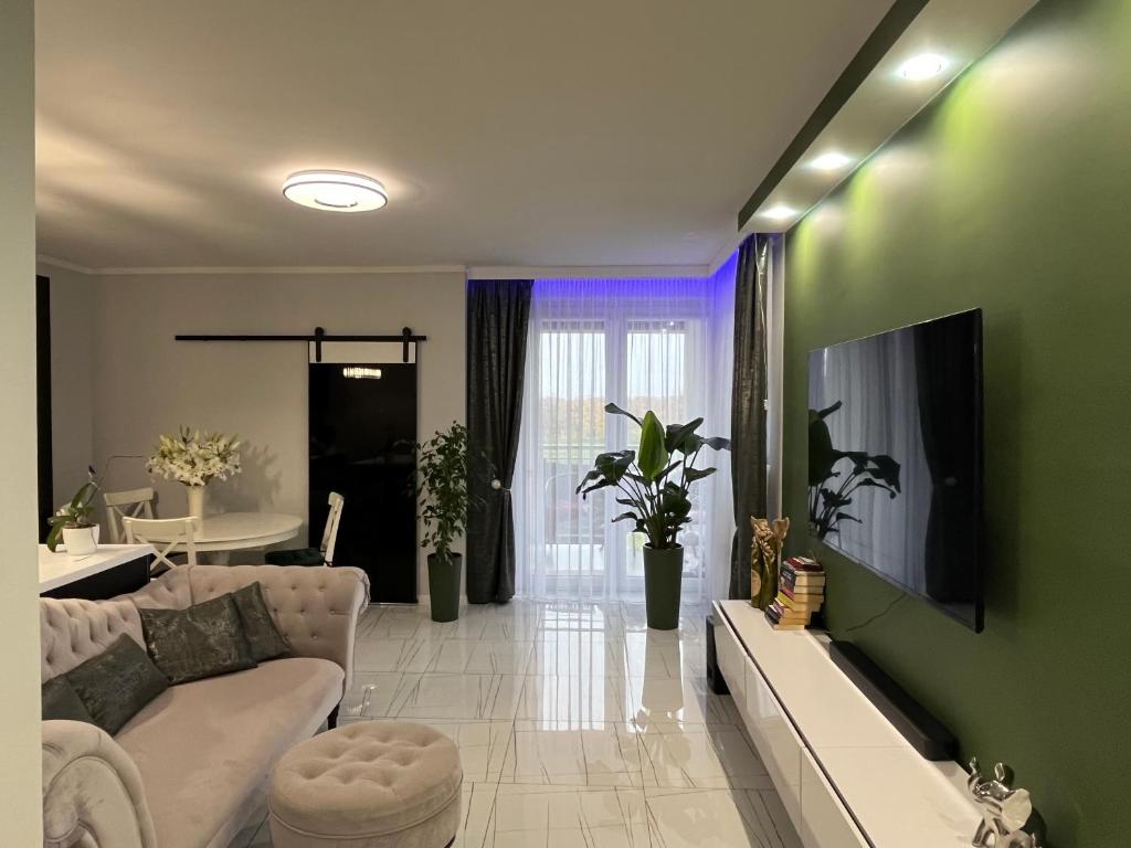 uma sala de estar com um sofá branco e uma parede verde em Apartament Słoneczna em Iwiczna