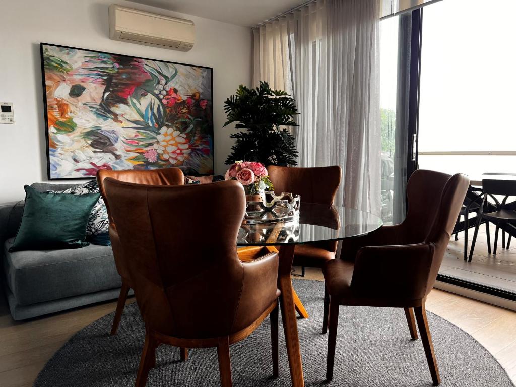 ein Esszimmer mit einem Glastisch und Stühlen in der Unterkunft Ruckers Hill Northcote Penthouse in Melbourne