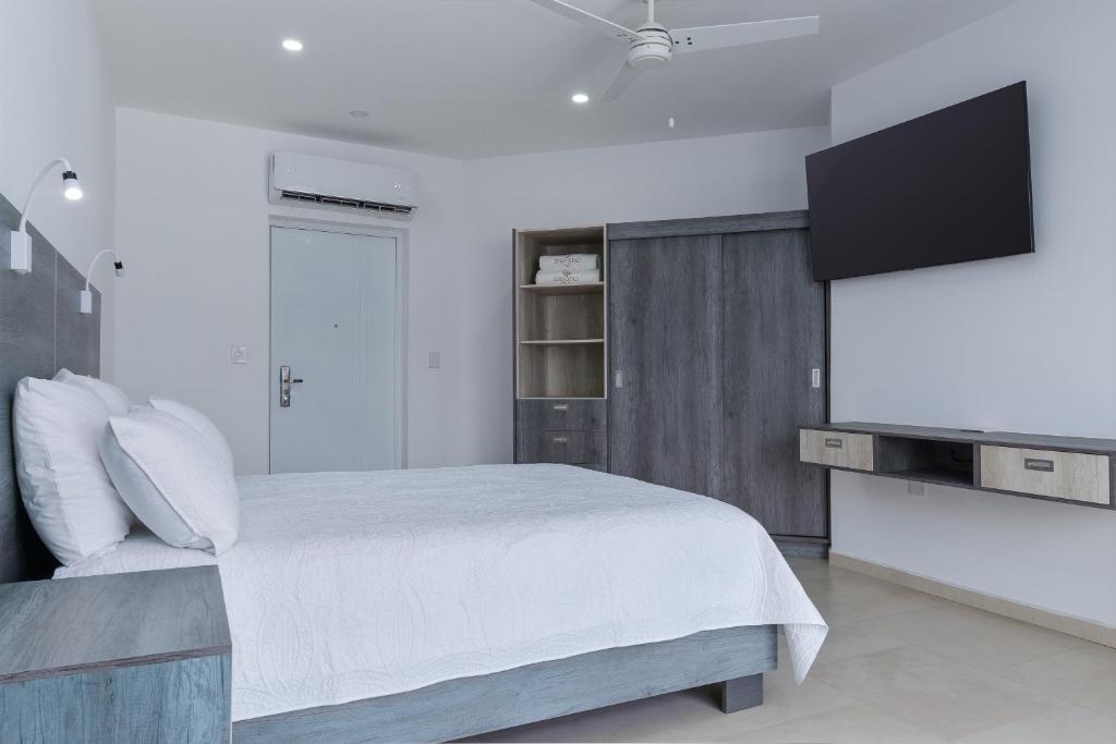 um quarto com uma cama e uma televisão de ecrã plano em Casa Xtao Hotel em Santa Cruz, Huatulco