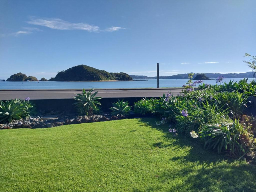 a lawn with a view of the water at Bayview Motel in Paihia