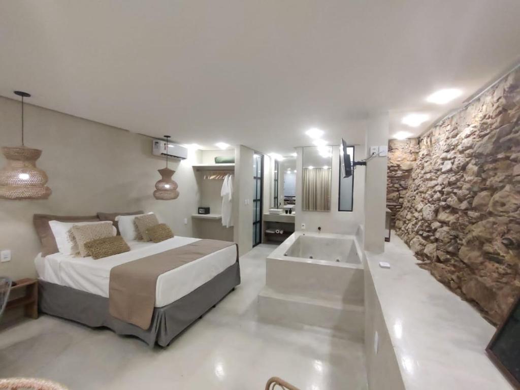 ein Schlafzimmer mit einem großen Bett und einer Badewanne in der Unterkunft Casa Oyá in Morro de São Paulo