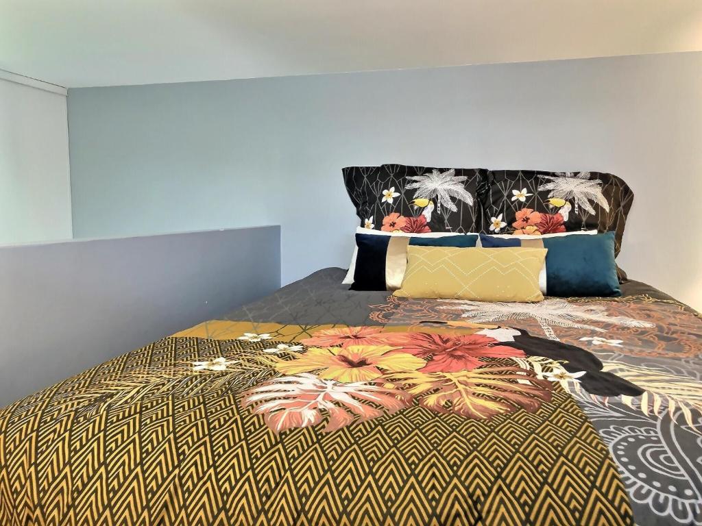 a bedroom with a large bed with a colorful bedspread at L'idéal Mairie de Montreuil in Montreuil
