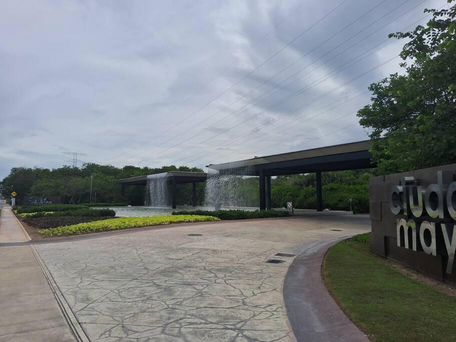 Departamento Ciudad MayaKoba 2 habitaciones في بلايا ديل كارمن: مبنى فيه نافورة وسط حديقة