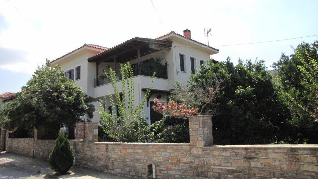 una casa blanca detrás de una pared de ladrillo en Rafaela House, en Milina