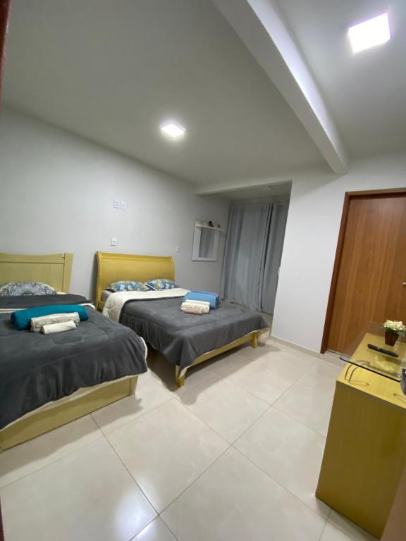 Pokój hotelowy z 2 łóżkami i biurkiem w obiekcie Apartamento Fruto da Terra 303 w mieście Caparaó Velho