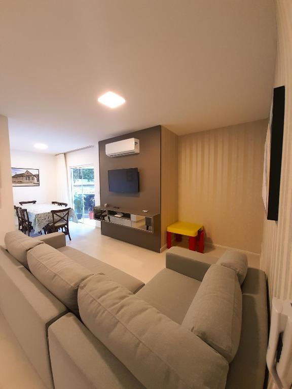 a living room with a couch and a tv at Apto novo no centro in Pomerode