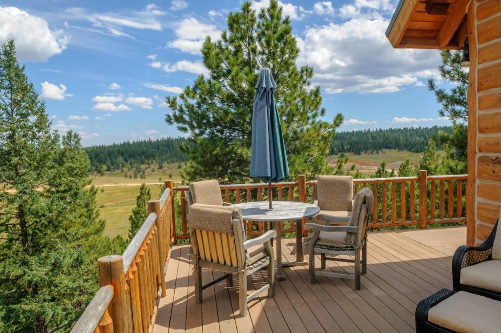 a deck with a table and chairs and an umbrella at Strawberry Fields in Duck Creek Village