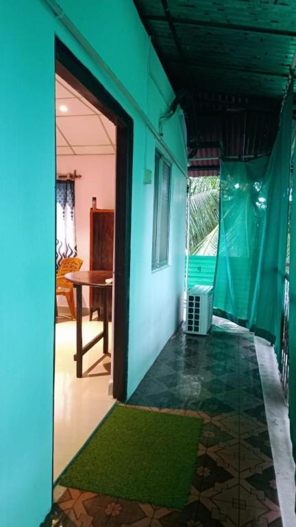 an open door to a room with a green wall at The Leisure Home Stay in Shādipur