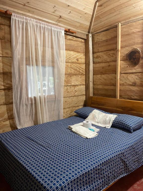 a bedroom with a bed in a wooden cabin at Finca Dos Apóstoles 