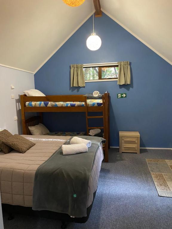 a bedroom with two beds and a blue wall at Dakune Chill - The Chalet in Ohakune