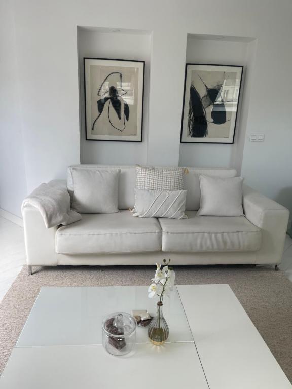 un salon avec un canapé blanc et une table dans l'établissement La suite Monceau, à Paris