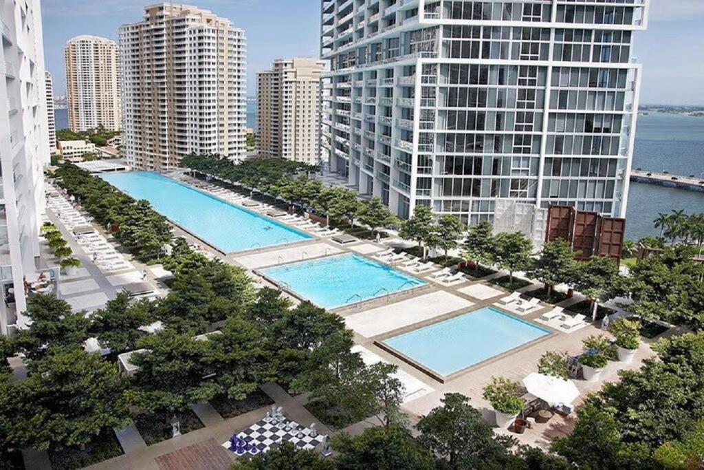an aerial view of two pools in a city with buildings at Highest floor Icon W Brickell Location in Miami
