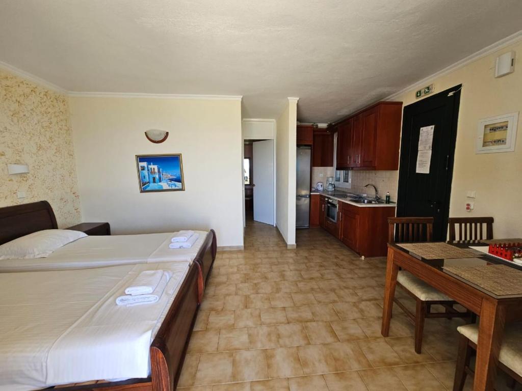 sypialnia z łóżkiem i stołem oraz kuchnią w obiekcie Corfu Glyfada Apartment 45 w mieście Glifada