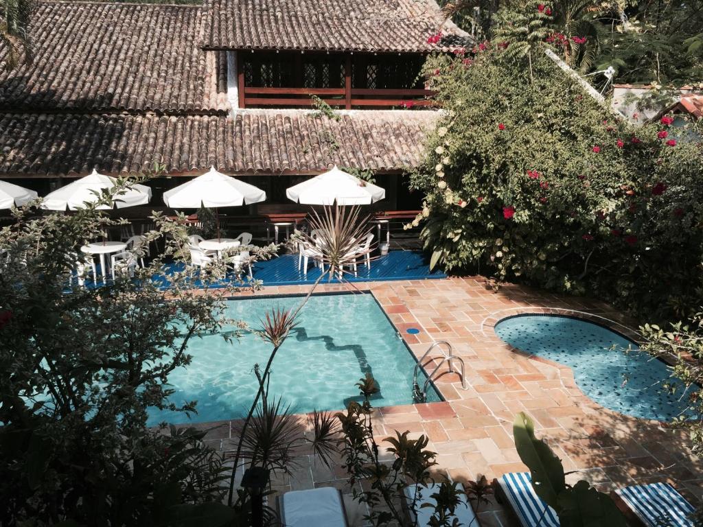 an overhead view of a swimming pool with chairs and umbrellas at Pousada Albatroz in Ubatuba