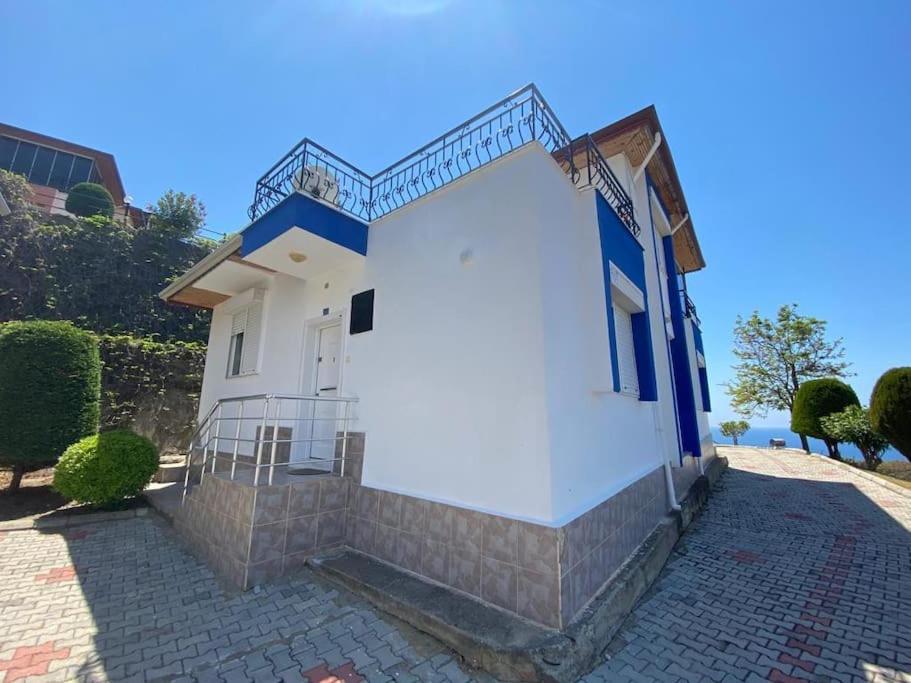 Turkish riviera sea view detached villa في غازي باشا: مبنى ابيض وزرق وعليه درج