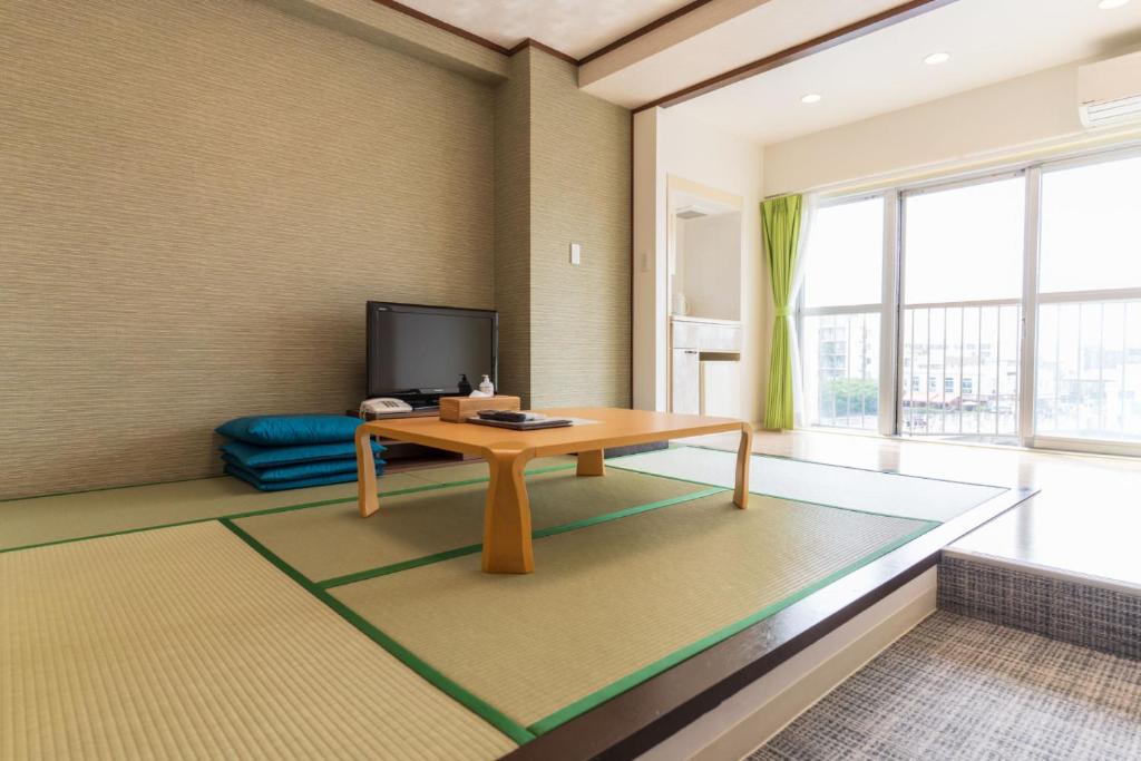 sala de estar con mesa y TV en 紀州鉄道片瀬江ノ島ホテル, en Fujisawa