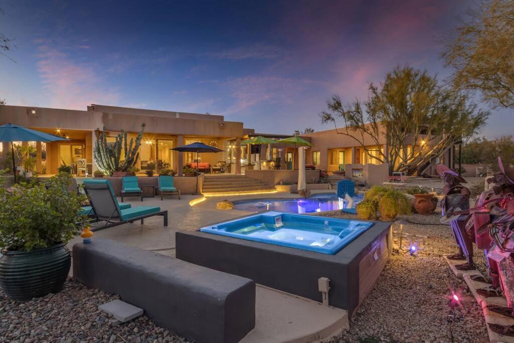 um quintal com uma banheira de hidromassagem e uma casa em Serene Resort Style Living w/ Dream Backyard em Scottsdale