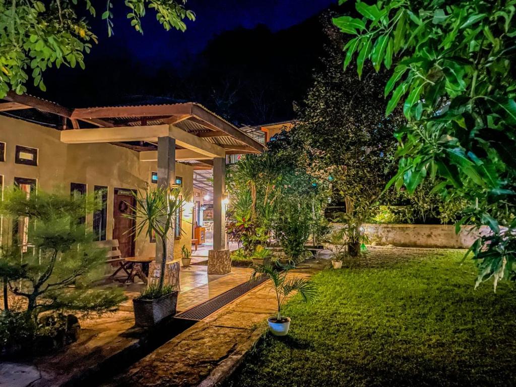 a garden at night with a house with a patio at G-Rima Home Stay in Labuan Bajo