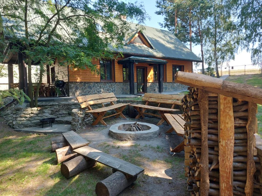 a log cabin with picnic tables and a fire pit at Szewnia Dolna in Szewnia