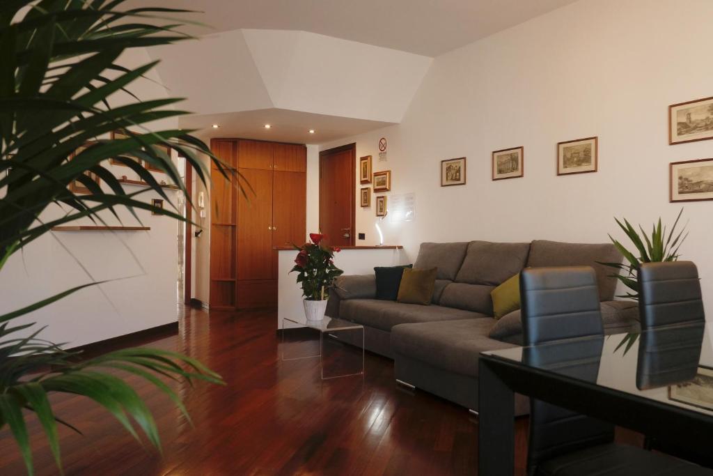 BWR - Appartamenti in zona Sempione-Tre torri, via Alberti في ميلانو: غرفة معيشة مع أريكة وطاولة