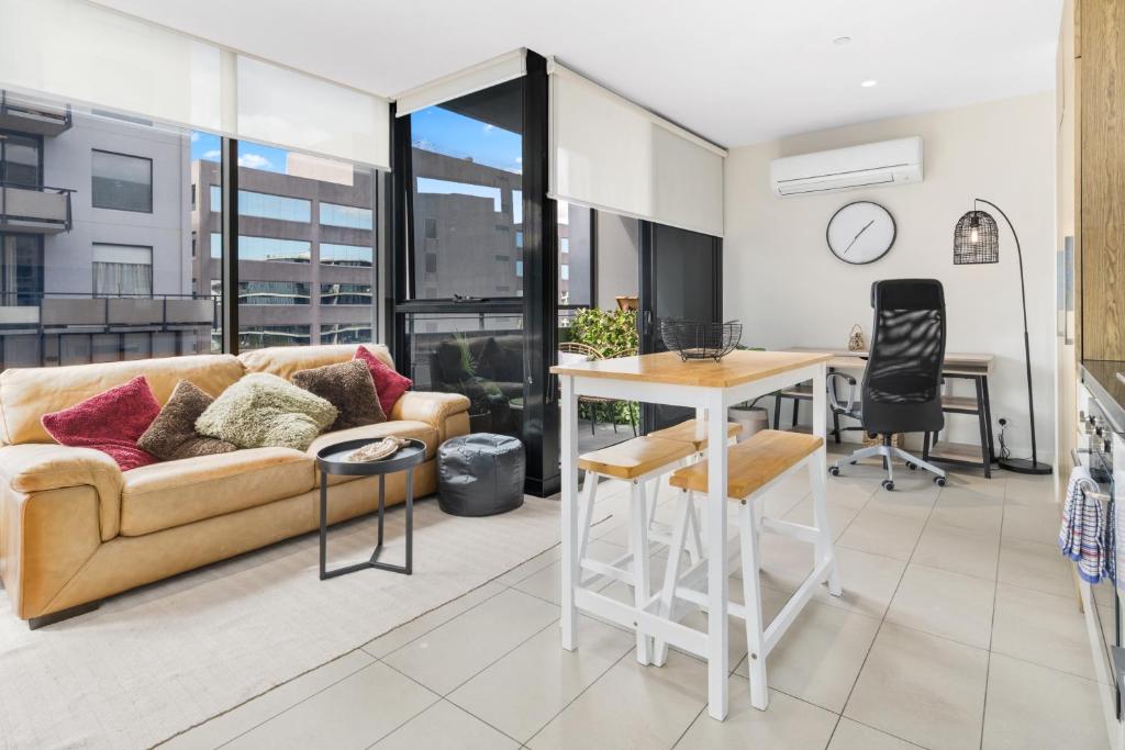 sala de estar con sofá y mesa en Escape To Melbourne - Stylish 1 Bedroom-Gym - Aircon -Balcony en Melbourne